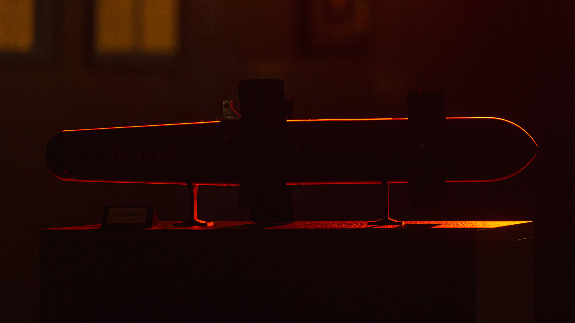 Deftak guided munition shown under controlled red illumination